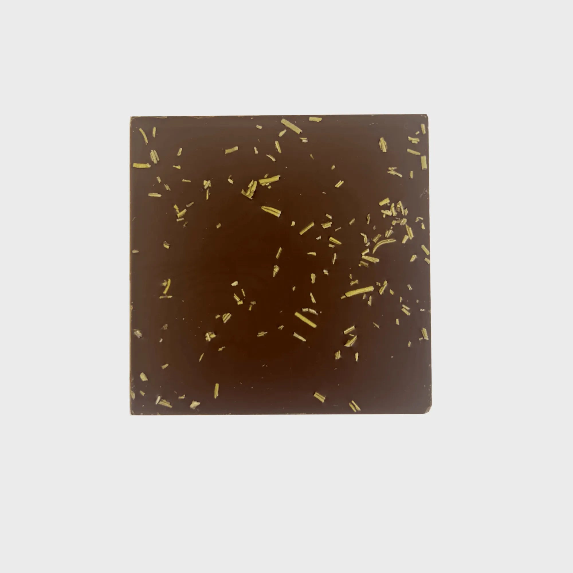 Decadent and rich caramelized rosemary chocolate bar beautifully presented on a white plate