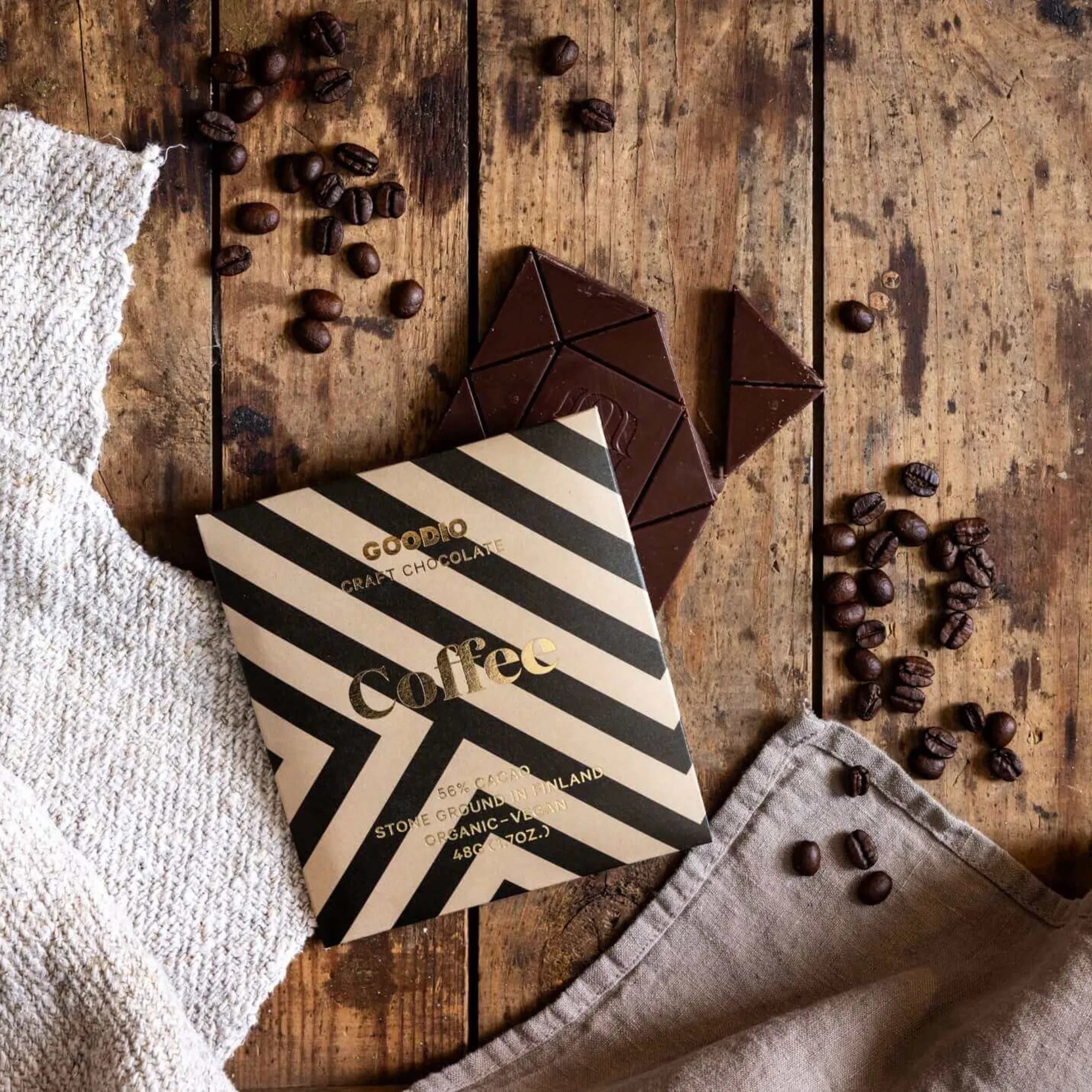  A stack of coffee chocolate 56% bars on a wooden table, showcasing the smooth and luxurious texture